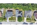 Aerial view of a home featuring solar panels on the roof, nestled in a residential neighborhood with mature trees at 478 Acacia Tree Way, Kissimmee, FL 34758