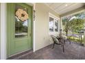 Inviting front porch featuring a green door, seating area, and manicured landscaping at 9121 Laureate Blvd, Orlando, FL 32827