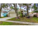 Inviting one story home featuring manicured lawn, mature trees, and charming curb appeal at 10934 Rushwood Way, Clermont, FL 34714