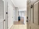 Inviting entryway featuring tile flooring, white doors, and a glimpse into the open-concept living space at 1361 Tuscan Ter # 7303, Davenport, FL 33896