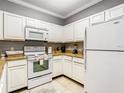 Efficient kitchen with white appliances, ample counter space, and white cabinetry at 1361 Tuscan Ter # 7303, Davenport, FL 33896