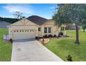 Charming single-story home with a two-car garage, manicured lawn, and lovely landscaping at 1405 Hillsborough Way, Kissimmee, FL 34759