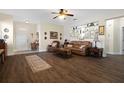 Cozy living room featuring hardwood floors, a ceiling fan, and a decorative display shelf at 1405 Hillsborough Way, Kissimmee, FL 34759