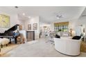 Open-concept living area with tile flooring, a piano, and ample seating, creating an inviting and stylish space at 1452 Mickelson Ct, Davenport, FL 33896