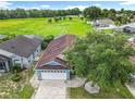 Aerial view of home with lush green field in background, mature landscaping and a large driveway at 1515 Oak Hill Trl, Kissimmee, FL 34747