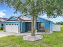 Charming blue single-story home featuring a screened entryway and well-manicured front yard at 1515 Oak Hill Trl, Kissimmee, FL 34747