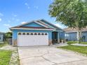 Charming blue single-story home with a well-manicured lawn and a white two-car garage at 1515 Oak Hill Trl, Kissimmee, FL 34747