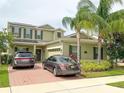 Inviting two story home featuring lush landscaping, solar panels, brick driveway, and a two car garage at 15230 Evergreen Oak Loop, Winter Garden, FL 34787