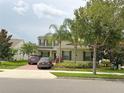 Attractive home featuring lush landscaping, two parked cars, and a well-manicured lawn at 15230 Evergreen Oak Loop, Winter Garden, FL 34787