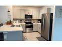 Modern kitchen featuring stainless steel appliances, granite countertops, and ample cabinet space at 1940 Egret Meadows Ave, Kissimmee, FL 34744