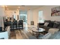 Open-concept living room with hardwood floors and large windows, connected to the kitchen at 1940 Egret Meadows Ave, Kissimmee, FL 34744