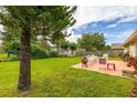 Spacious backyard featuring a patio area with outdoor seating, lush green grass, and mature trees at 2569 Tandori Cir, Orlando, FL 32837