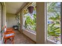 Cozy screened-in porch with seating, hanging plants, and a view of the tropical landscaping at 2569 Tandori Cir, Orlando, FL 32837