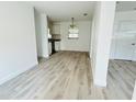Open-concept living area showcasing wood-look floors, neutral paint, and seamless flow to the kitchen at 329 N Hart Blvd, Orlando, FL 32835