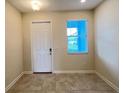 Neutral entryway features a front door, window with blinds, and tiled flooring at 4634 Tribute Trl, Kissimmee, FL 34746