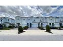 Street view of attractive light blue two-story townhomes, each with individual garages and paved driveways at 4634 Tribute Trl, Kissimmee, FL 34746