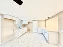 Modern kitchen featuring white cabinets, updated countertops, and new marble-patterned tile flooring at 4917 Easton St, Lake Wales, FL 33859