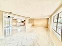 Open-concept living room and kitchen area with bright white cabinets and sleek marble-patterned tile flooring at 4917 Easton St, Lake Wales, FL 33859