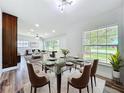 Bright dining area featuring a glass table, plush chairs, and large windows offering a view of the outdoors at 5312 Kingswood Dr, Orlando, FL 32810