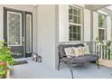 Cozy front porch with comfortable seating, decorative pillows, stylish lanterns and lovely flowering plants at 6808 Goldflower Ave, Harmony, FL 34773