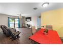 Bright living room with ample seating, wood flooring, and natural light from the sliding glass doors at 8 Orchid Ct, Kissimmee, FL 34759