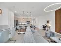 Open-concept living room featuring modern lighting, neutral decor, kitchen island with bar seating and dining area at 816 Longboat Dr, Davenport, FL 33896