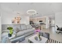 Open-concept living room featuring modern lighting, neutral decor, and kitchen island with bar seating at 816 Longboat Dr, Davenport, FL 33896
