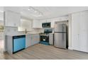 Modern kitchen with stainless steel appliances, white cabinetry, and quartz countertops at 12155 Pepperdine Pl, Orlando, FL 32826