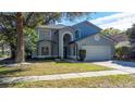 Charming two-story home with attached two-car garage, manicured lawn and mature trees at 13129 Cog Hill Way, Orlando, FL 32828