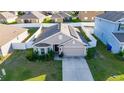 Aerial view of the residence features solar panels, fenced backyard, lush lawn and convenient two car garage at 1383 Buckeye Trace Blvd, Winter Haven, FL 33881