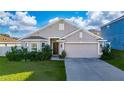 Charming single-story home features a two-car garage, well-manicured lawn, and mature shrubbery at 1383 Buckeye Trace Blvd, Winter Haven, FL 33881
