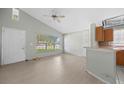 Light-filled living room featuring laminate flooring, ceiling fan, and breakfast bar at 1506 Brookebridge Dr, Orlando, FL 32825