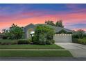 Charming exterior view of the home with manicured lawn and colorful sunset at 1525 Gants Cir, Kissimmee, FL 34744