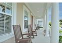 Charming front porch with rocking chairs and columns offers a relaxing outdoor space at 1855 Treasure Cv, Kissimmee, FL 34747