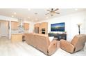 Open-concept living room featuring modern furnishings, a ceiling fan and a view of the kitchen at 1855 Treasure Cv, Kissimmee, FL 34747