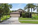 Attractive home with a tidy front lawn, mature shade trees, and a spacious two-car garage at 2612 Keswick Ct, Kissimmee, FL 34744