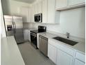 Well-equipped modern kitchen with stainless steel appliances, white cabinetry, and quartz countertops at 2626 Skyline Loop, Kissimmee, FL 34758