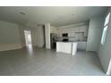 Open-concept living space with tile flooring, modern kitchen with stainless steel appliances, and plenty of natural light at 2626 Skyline Loop, Kissimmee, FL 34758