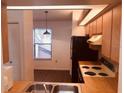 Functional kitchen with wooden cabinets and laminated countertops, appliances including a black refrigerator and an electric stove at 3036 S Semoran Blvd # S, Orlando, FL 32822