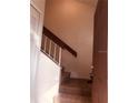 The home's staircase has carpeted steps, leading up to the next level, with a wooden handrail against the wall at 3036 S Semoran Blvd # S, Orlando, FL 32822