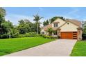 Lovely two-story home with a well-maintained lawn, charming landscaping, and a modern wood-tone garage door at 3109 Harvest Ln, Kissimmee, FL 34744