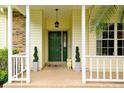 Inviting front porch with a classic green door, decorative plants, and neutral-toned siding and trim at 3109 Harvest Ln, Kissimmee, FL 34744