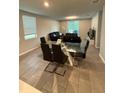 Open-concept dining area featuring a modern glass table, sleek chairs, and a view into the living room at 3342 Curlew Ave, Leesburg, FL 34748