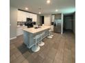 Spacious kitchen with a large center island, stainless steel appliances, and sleek white cabinets at 3342 Curlew Ave, Leesburg, FL 34748