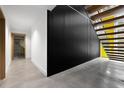 Hallway featuring modern staircase, a door to a bath with marble surround, and concrete floors at 3807 S Semoran Blvd, Orlando, FL 32822