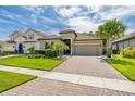Charming home with a tile roof, well-manicured lawn, and a brick driveway at 3837 Carrick Bend Dr, Kissimmee, FL 34746