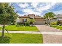 Charming home with a tile roof, well-manicured lawn, and a brick driveway at 3837 Carrick Bend Dr, Kissimmee, FL 34746
