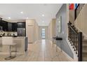 Bright foyer with marble floors, staircase, and sleek console table at 4547 Narrative Ln, Kissimmee, FL 34746
