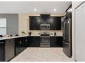 Modern kitchen featuring stainless steel appliances and sleek black cabinetry at 4547 Narrative Ln, Kissimmee, FL 34746
