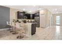 Eat-in kitchen featuring modern appliances, marble floors, and sleek breakfast bar at 4547 Narrative Ln, Kissimmee, FL 34746